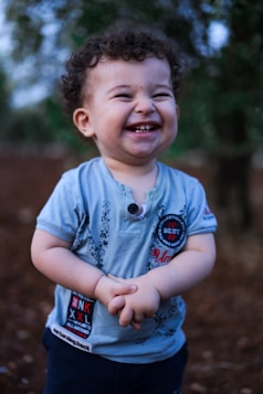 A little boy that is standing in the dirt