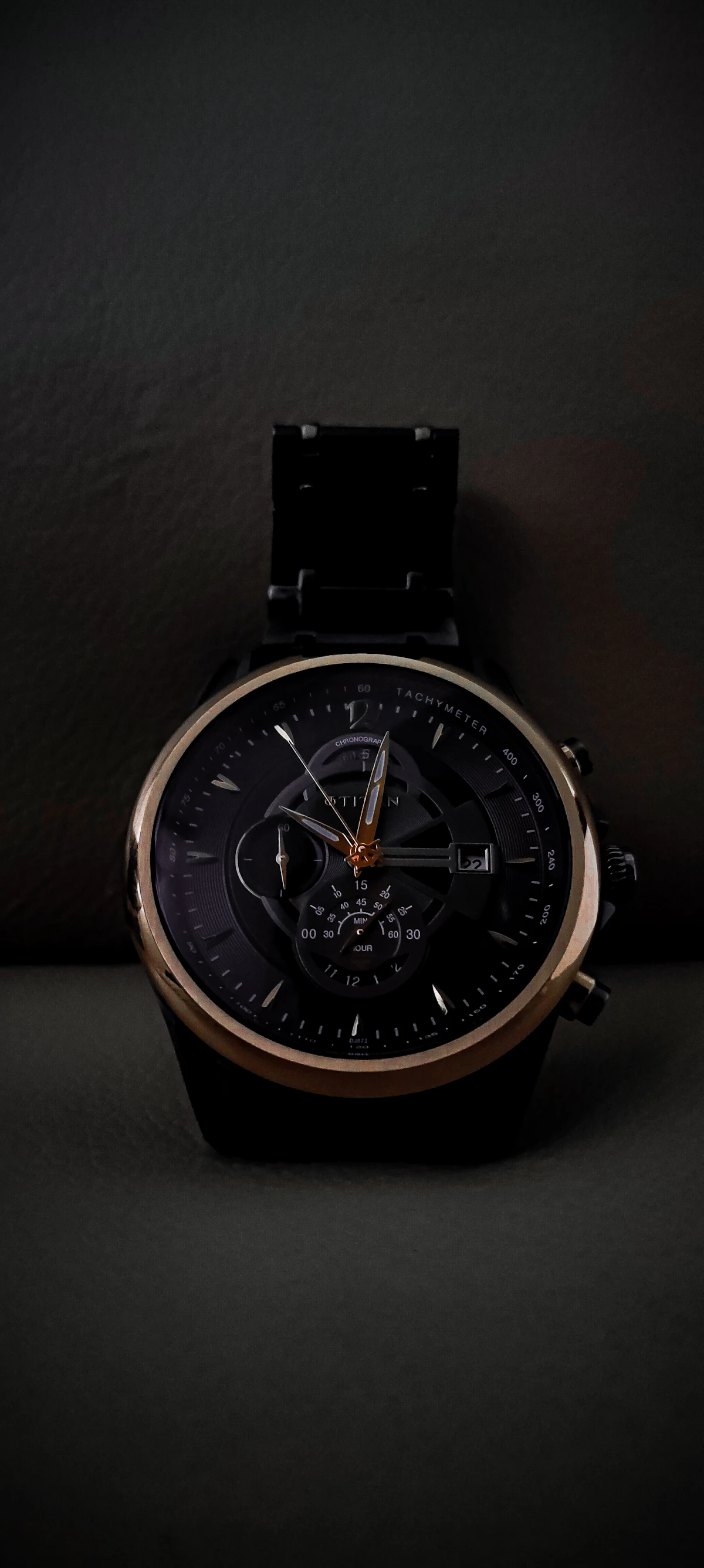 Close-up of a watch resting on a black surface