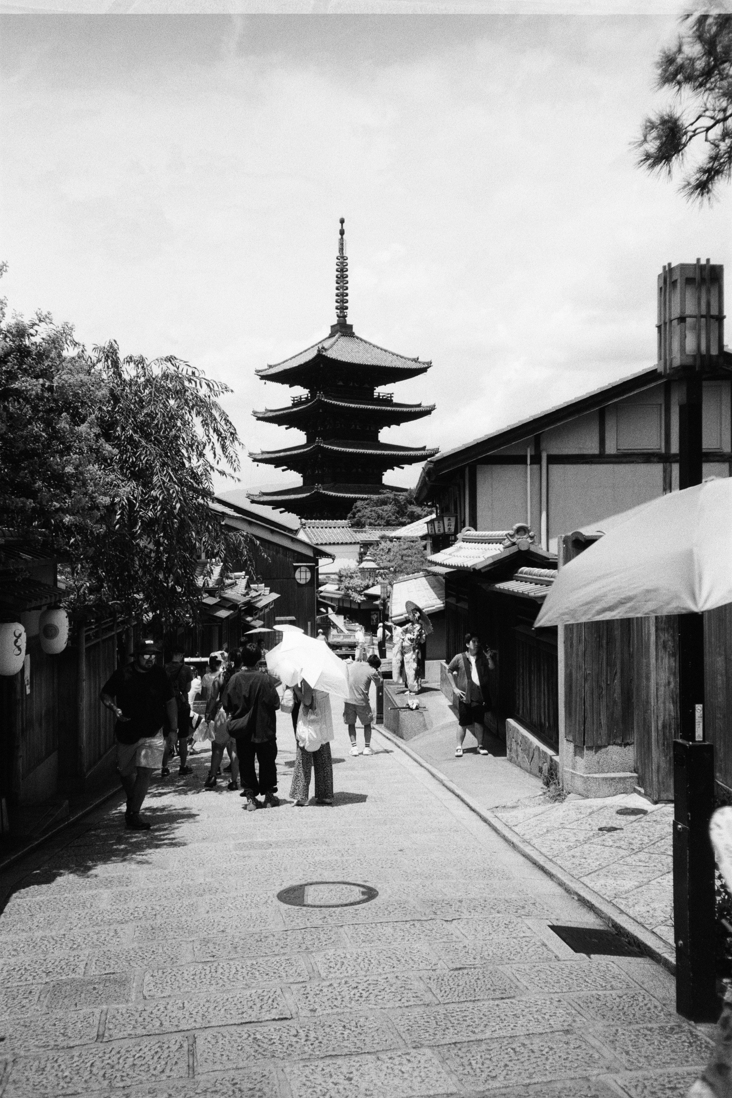 A black and white photo of people walking down a street