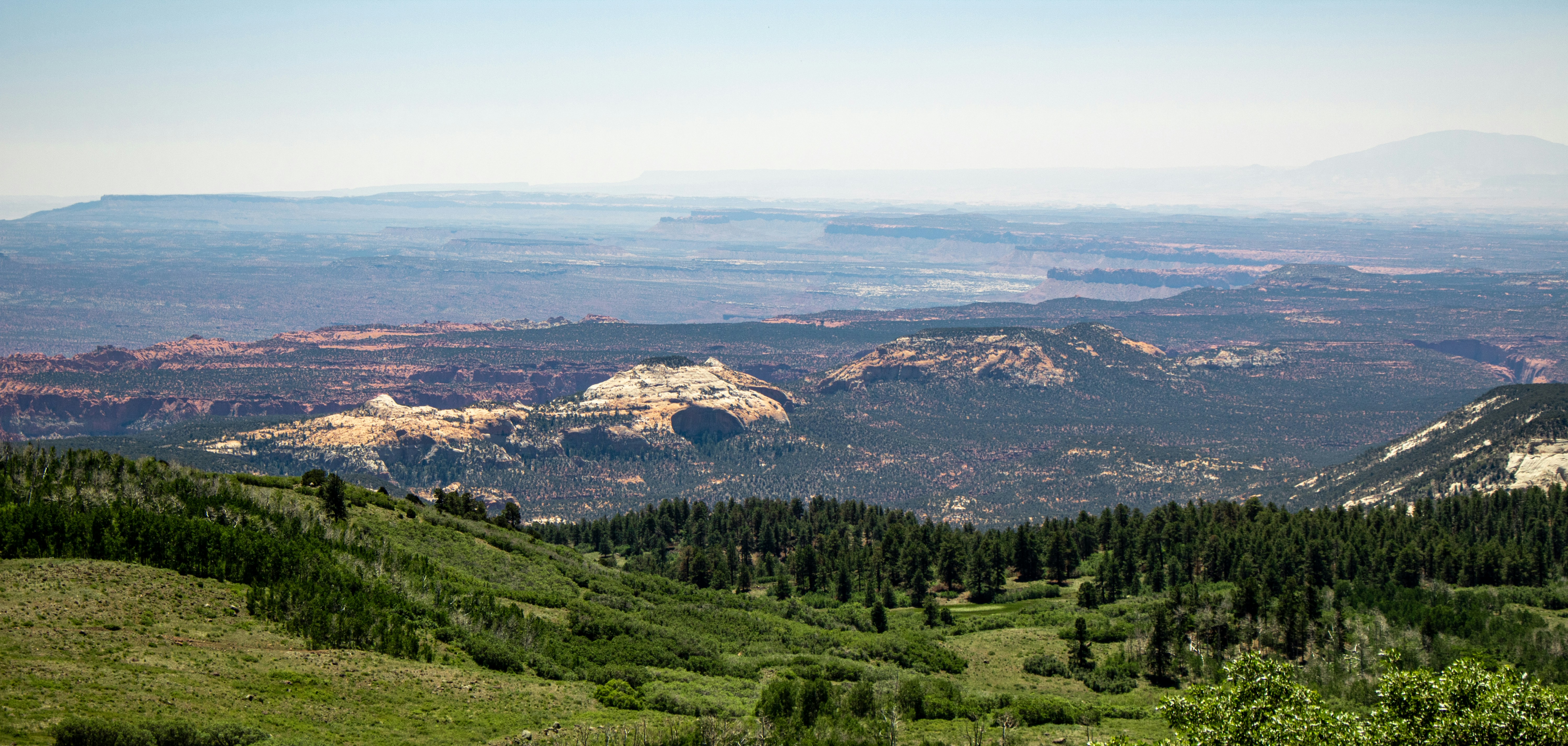 A view of a mountain range with trees and mountains in the background