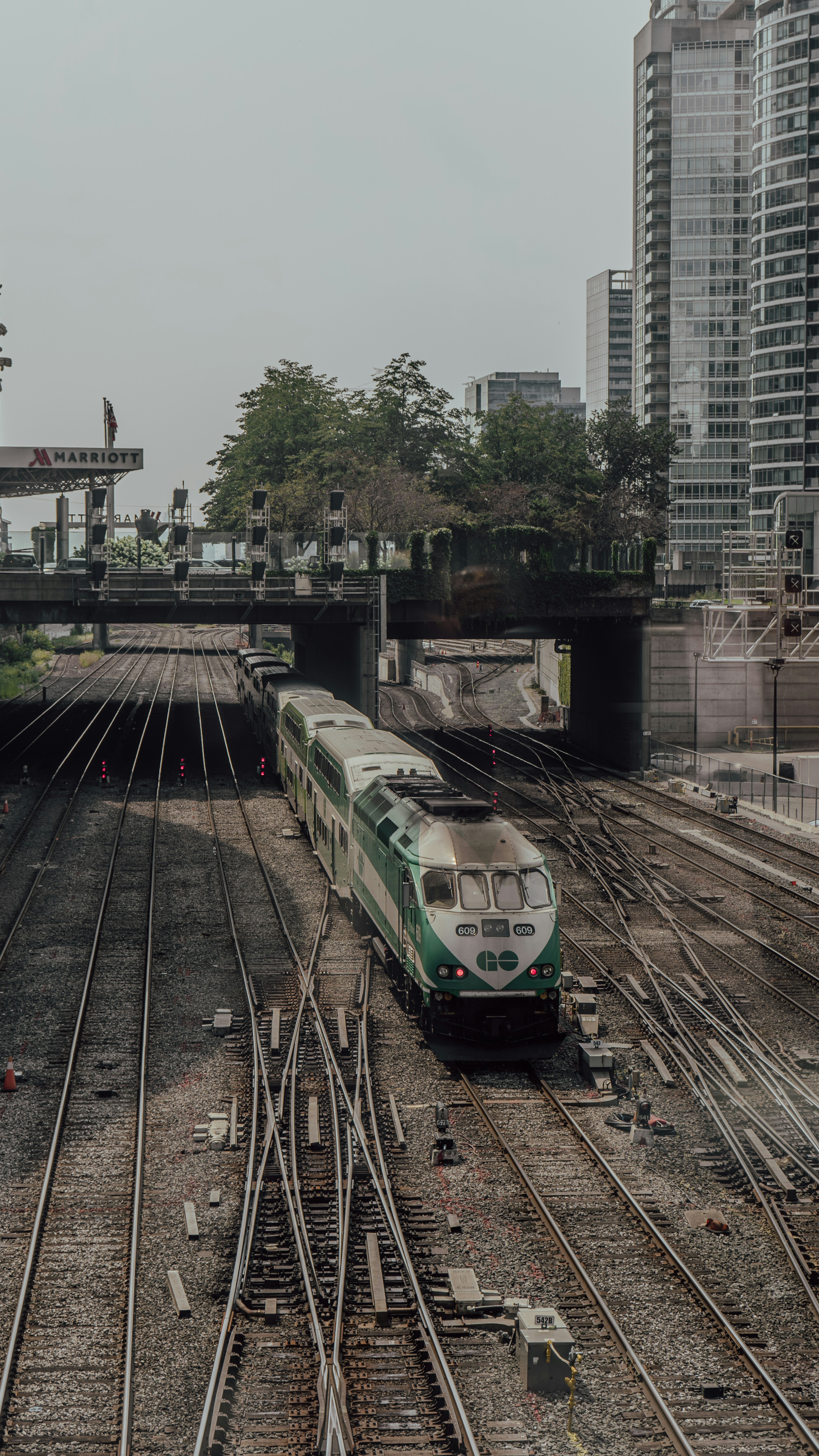 Kereta api yang melaju melalui stasiun kereta api di sebelah gedung-gedung tinggi