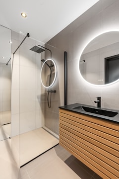 A bathroom with a sink, mirror and shower