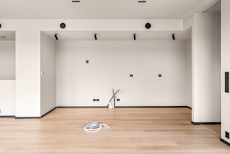 A room with a hard wood floor and white walls