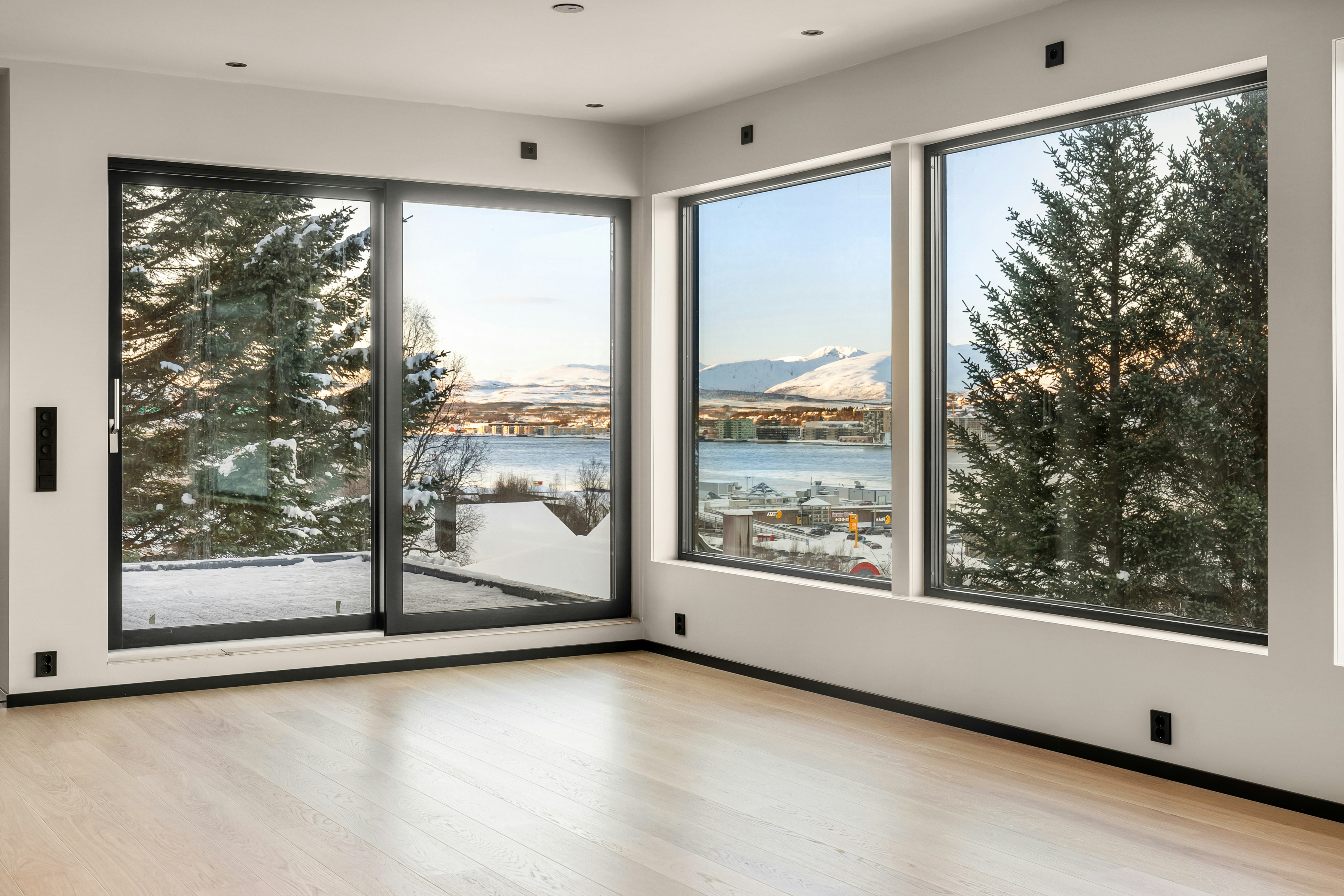 An empty room with large windows overlooking a lake