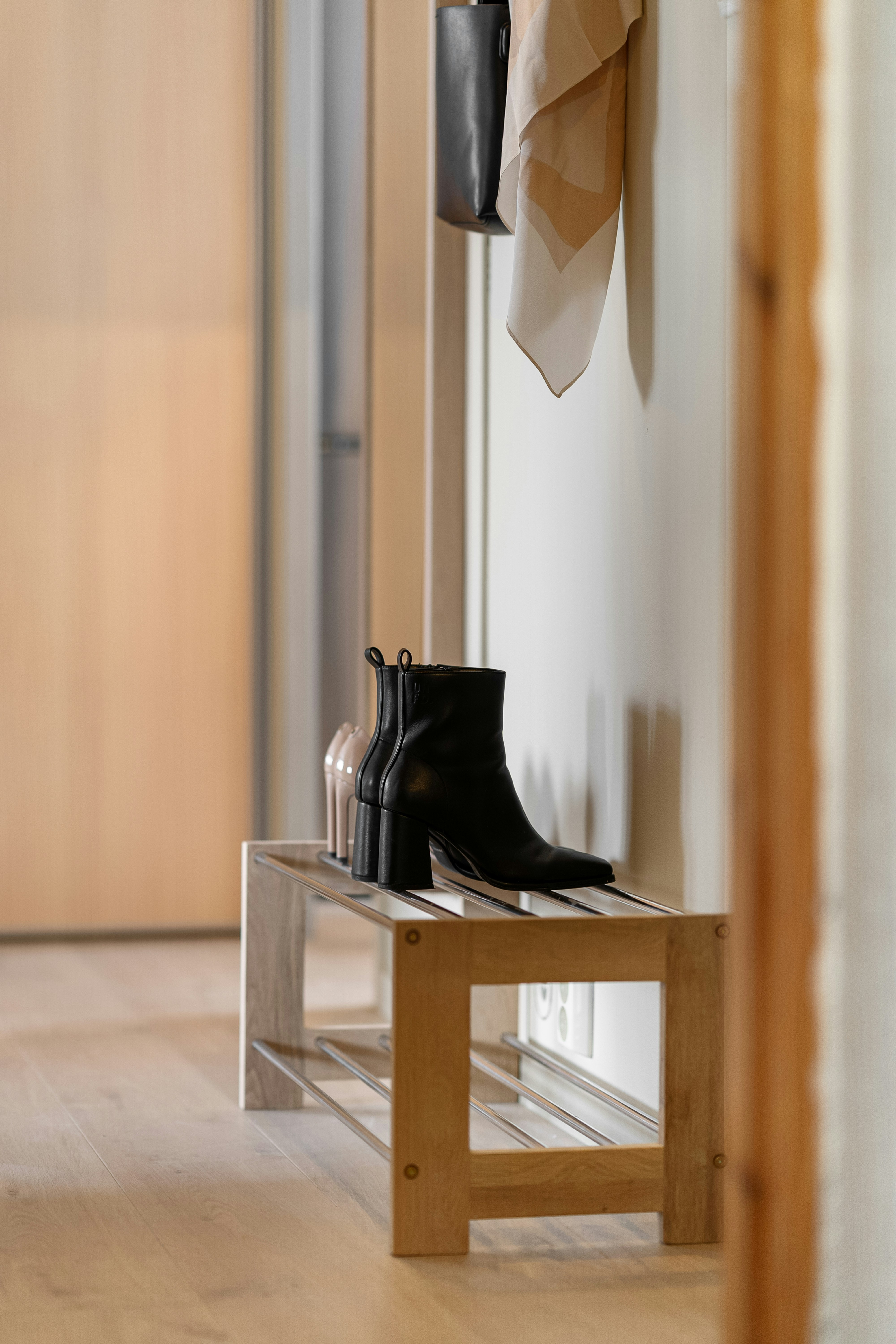 A pair of black boots sitting on top of a wooden bench