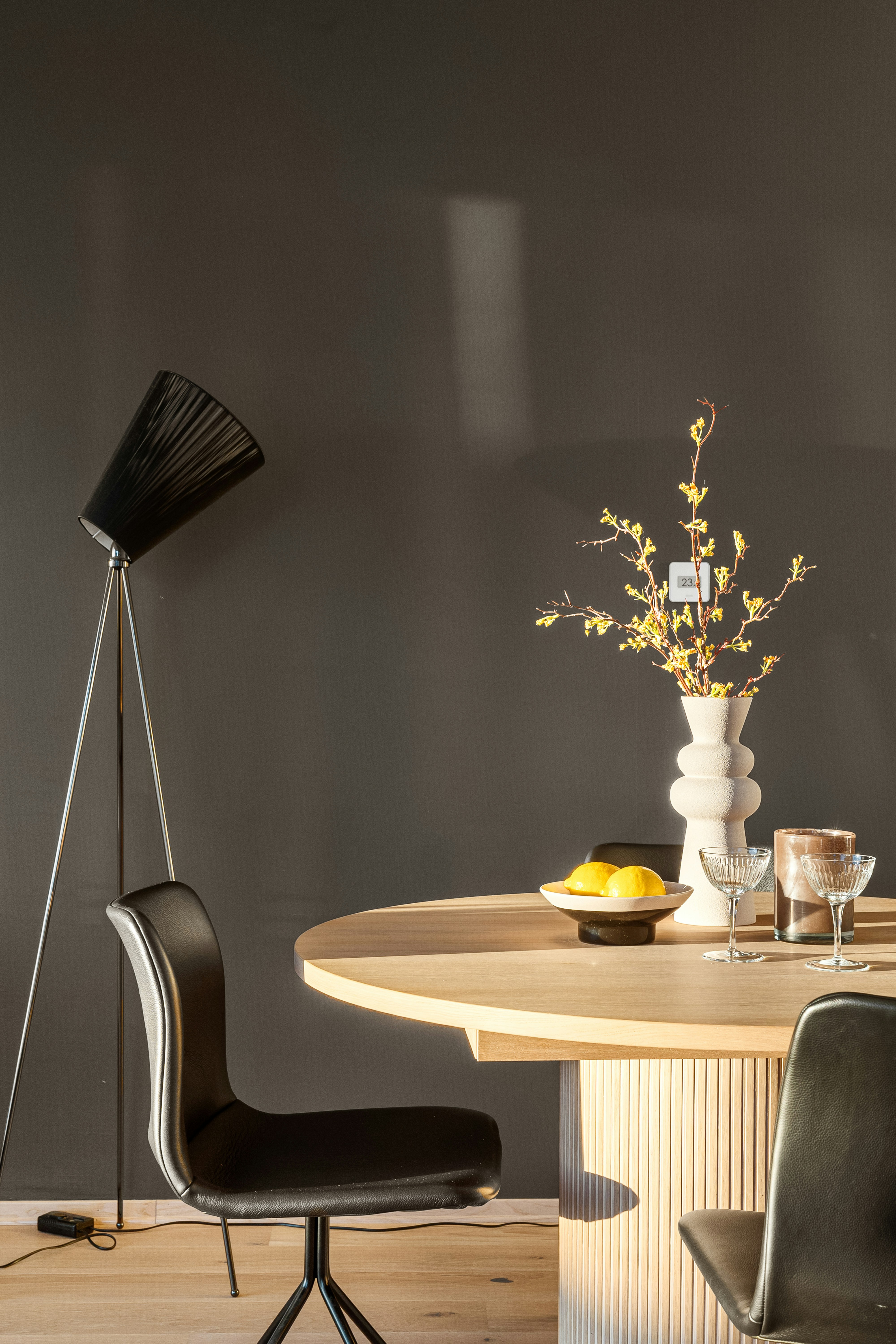 A dining room table with chairs and a vase of flowers