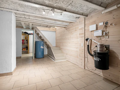 A room with a staircase and a trash can