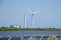 A wind farm with a wind turbine in the background