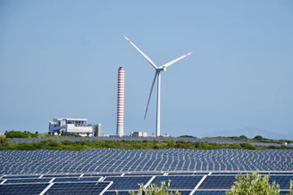 A wind farm with a wind turbine in the background