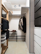 A walk in closet with clothes hanging on a rack