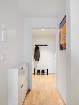 A white hallway with a coat rack and shoes