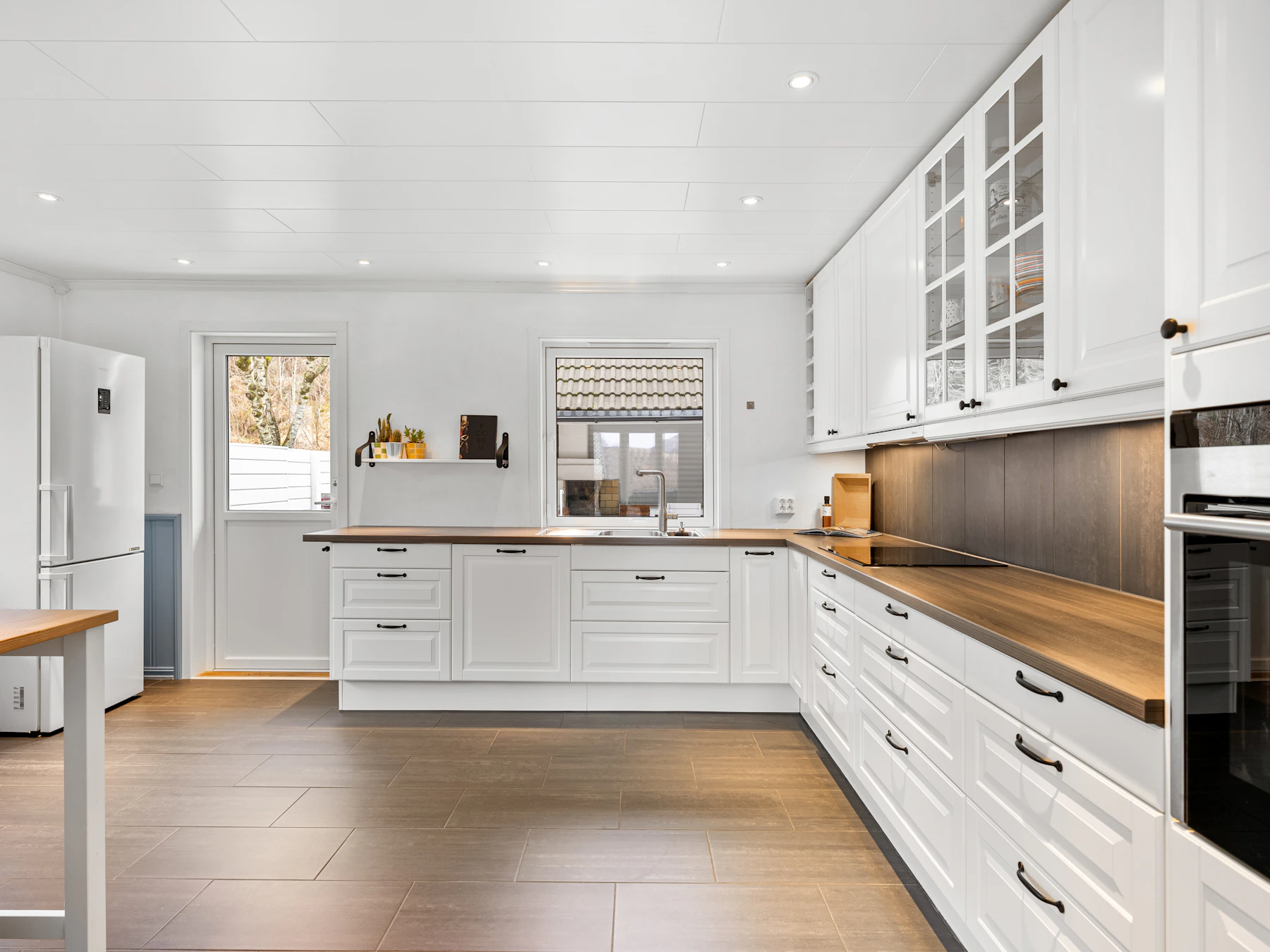 Bright kitchen with white cabinetry, a spacious island and warm wood flooring