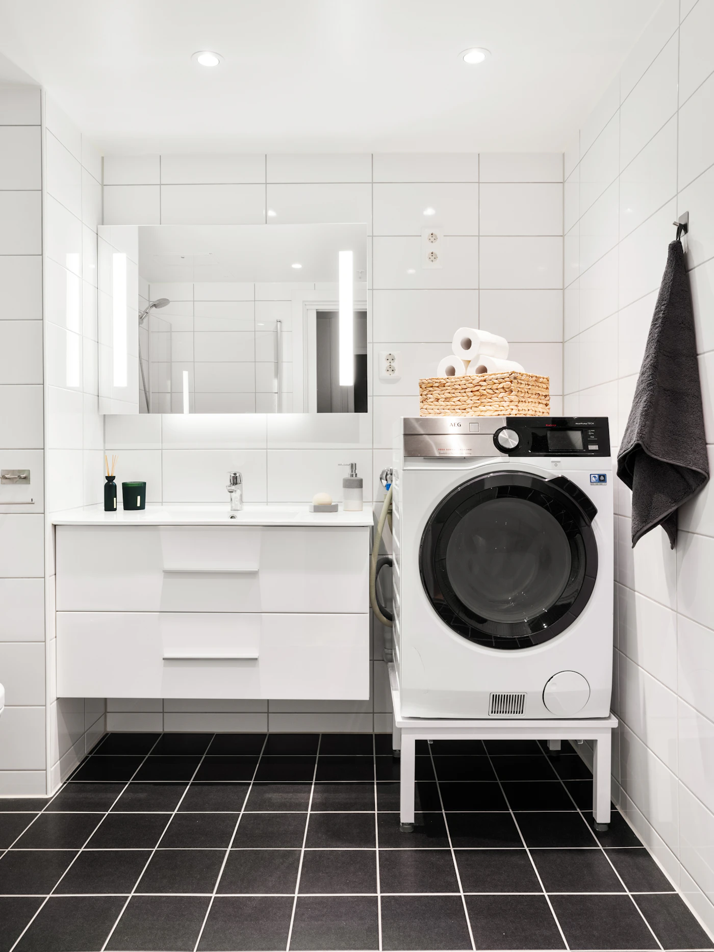 Clean white bathroom and laundry space with towels