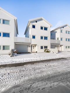 A row of white houses sitting on top of snow covered ground