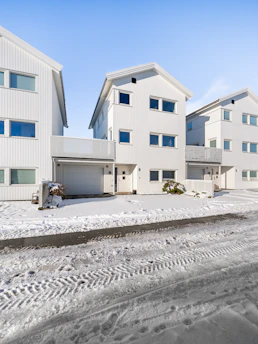 A row of white houses sitting on top of snow covered ground