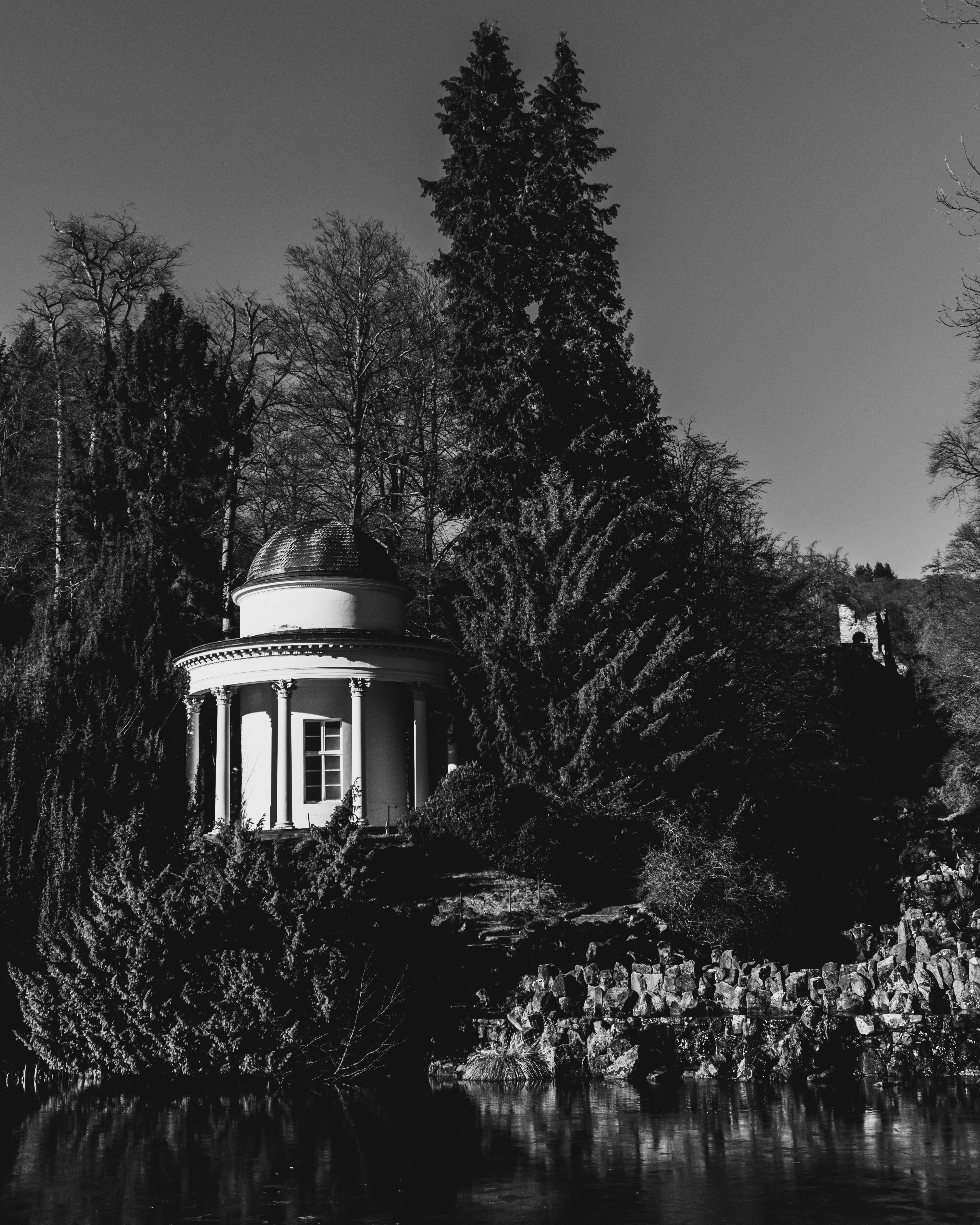 A black and white photo of a gazebo in a park