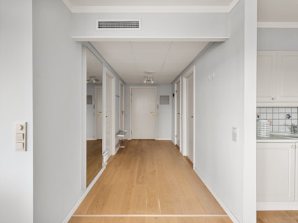 An empty room with a wood floor and white walls