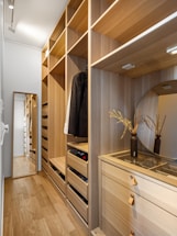 A walk in closet with a mirror and drawers