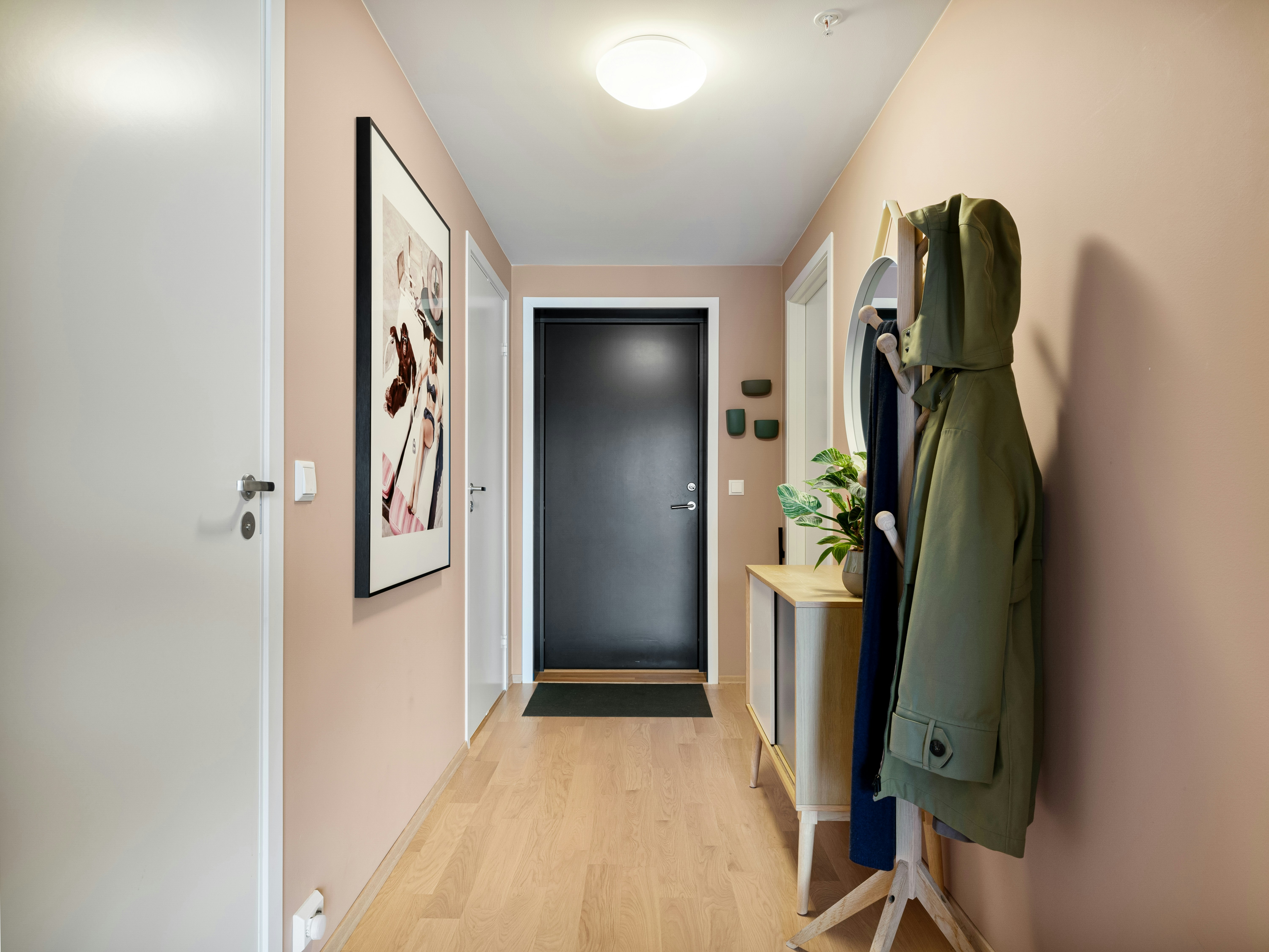 A hallway with a coat rack and coat hanging on the wall