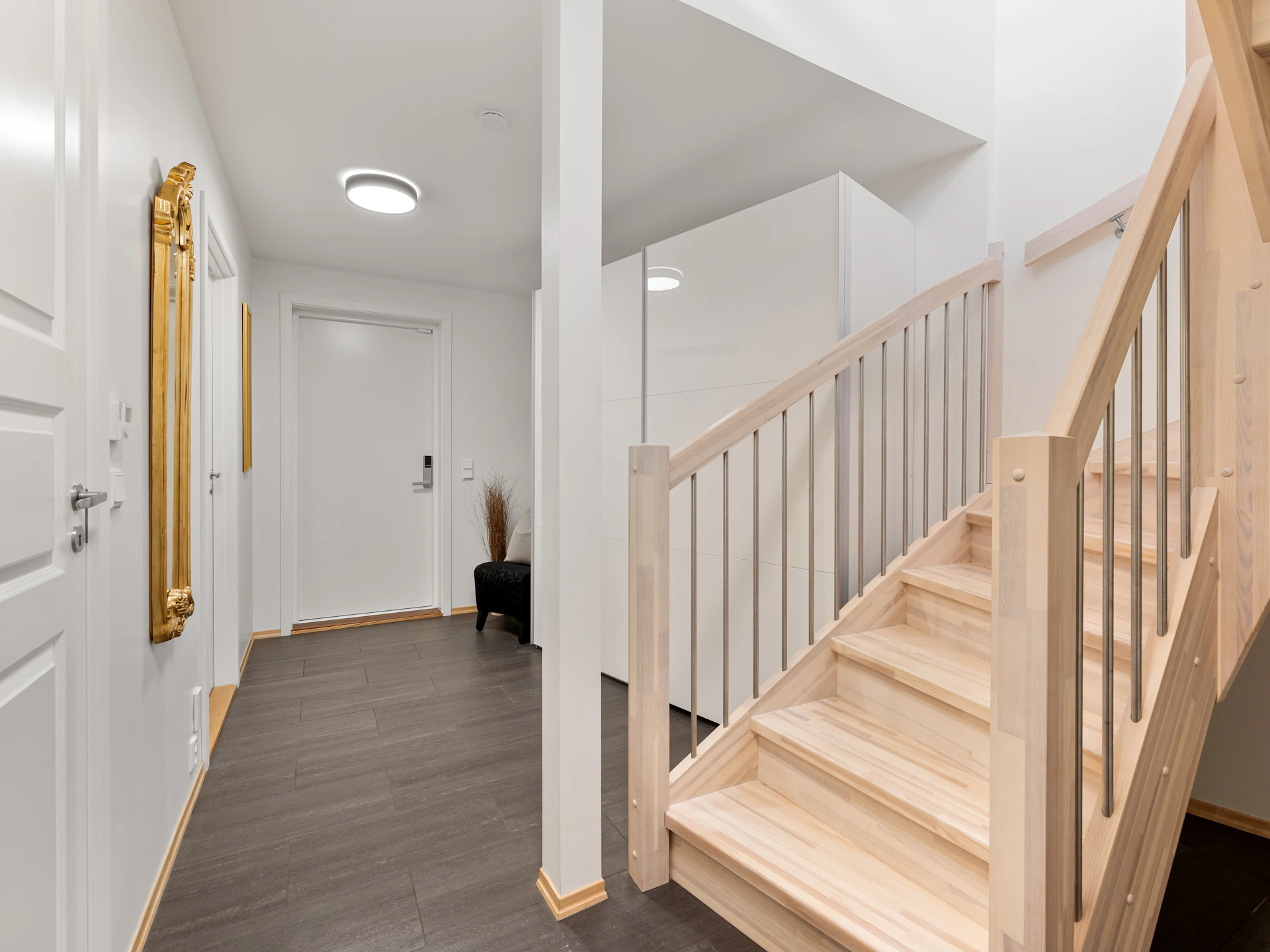 A hallway with a staircase and a white door