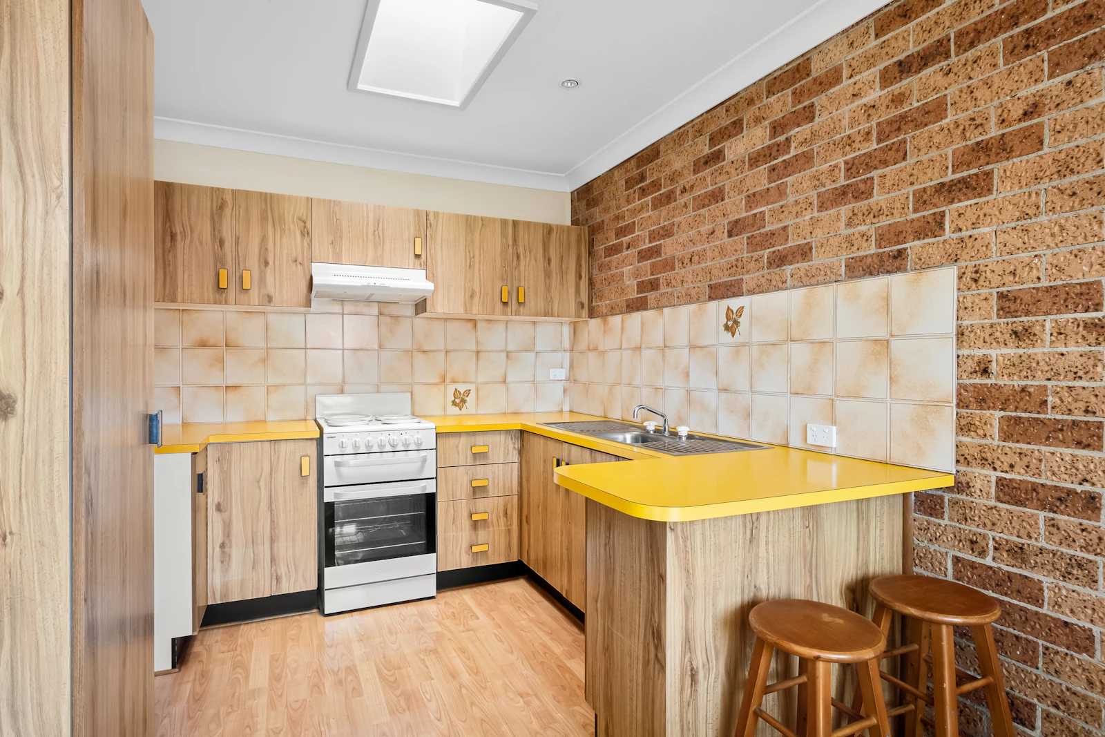 Yellow kitchen counter with seating arranged along one edge