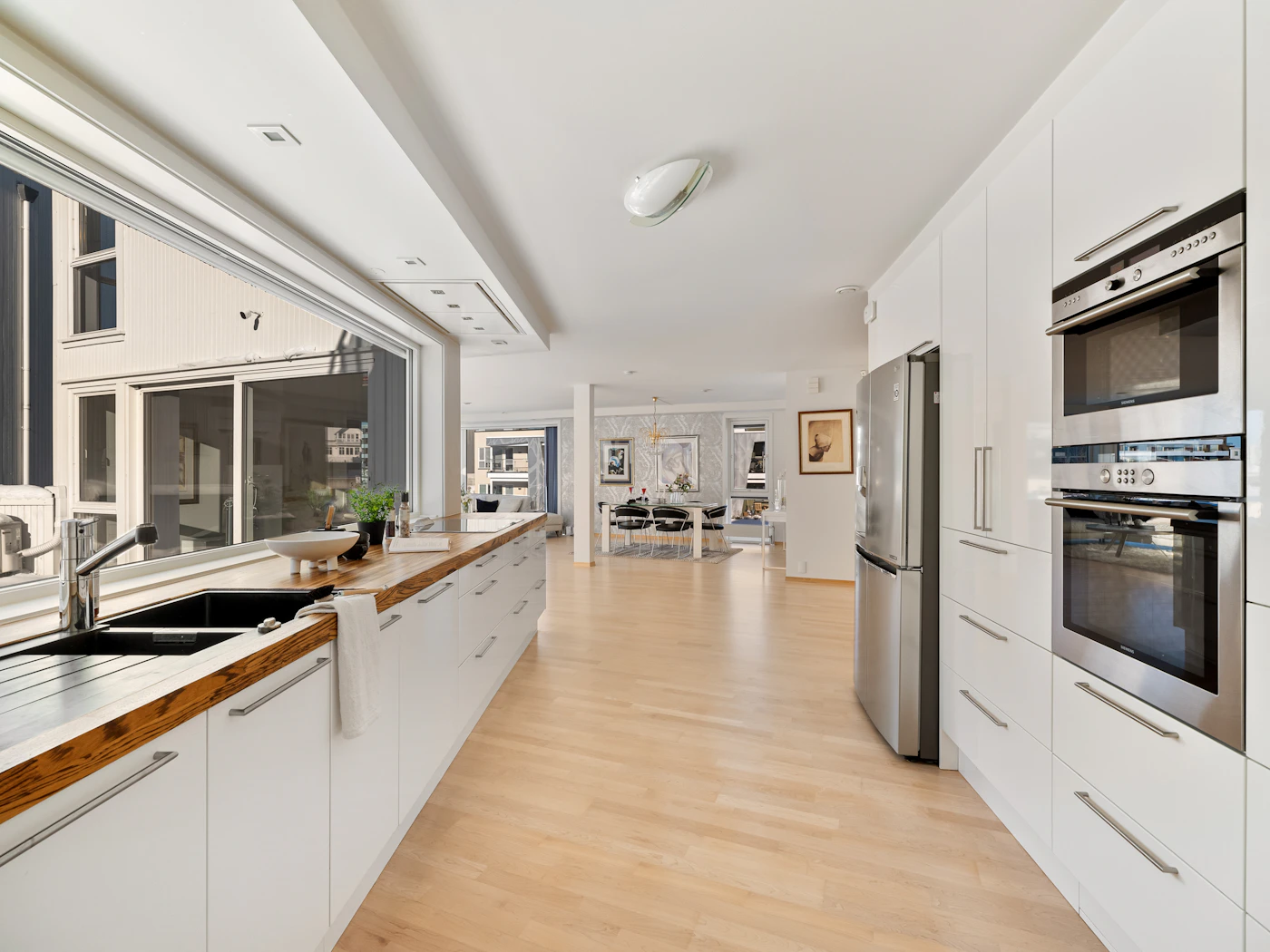 Bright modern kitchen with wood counters and white cabinets