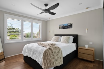 A bedroom with a black ceiling fan