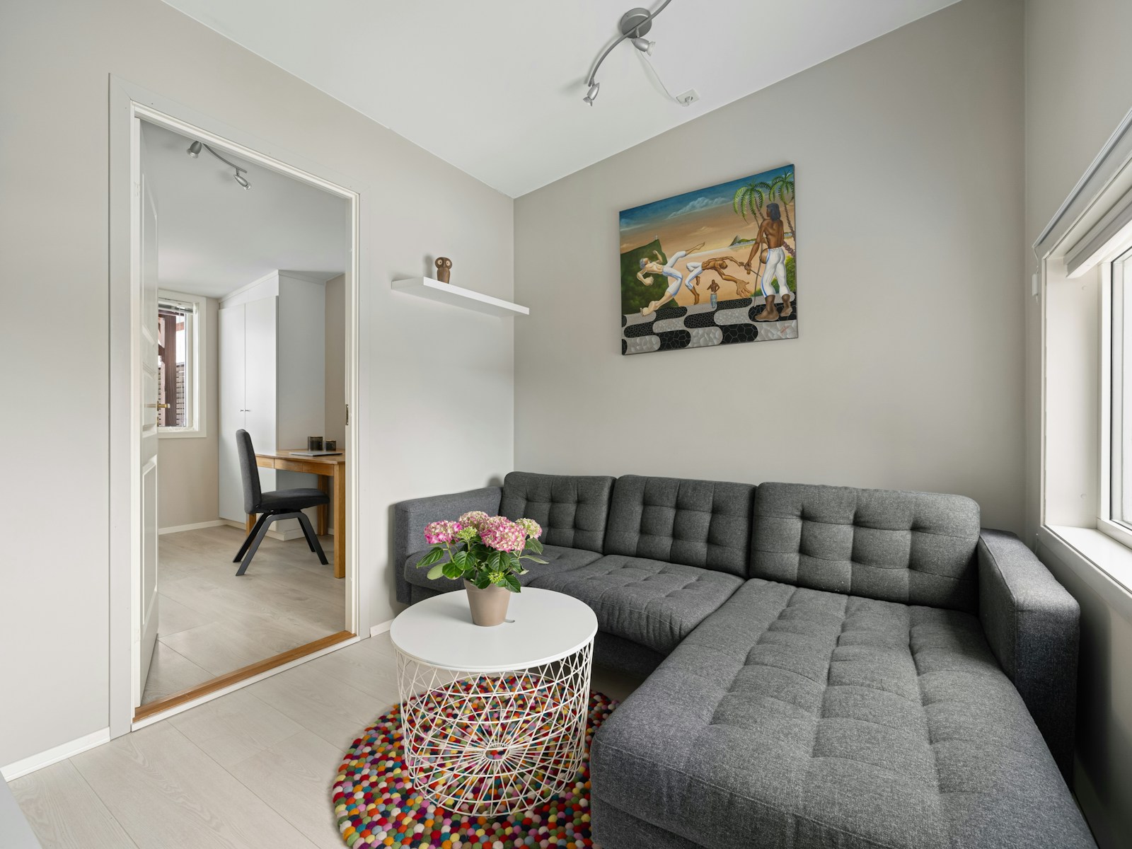 small studio apartment with gray sectional sofa and round coffee table