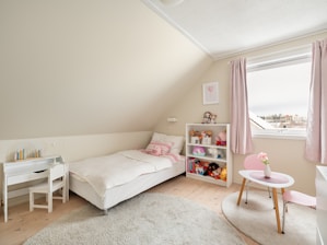 A bedroom with two beds and a desk