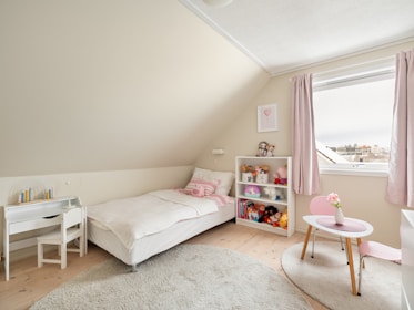 A bedroom with two beds and a desk