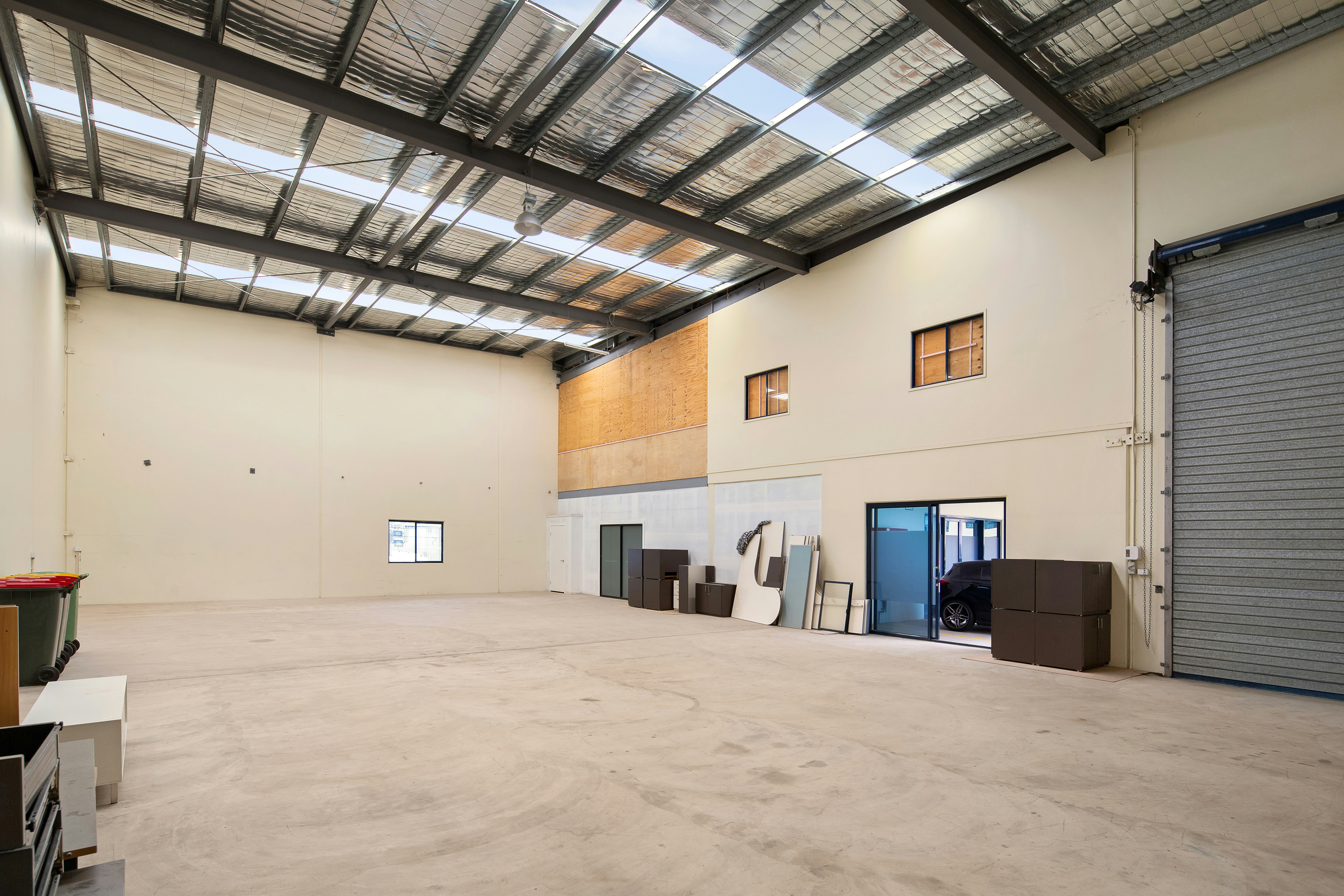 Almacén industrial vacío con suelos de hormigón pulido y techos altos.