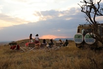 A group of people sitting in chairs in a field