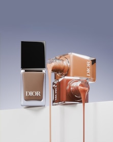 A bottle of dior's nail polish next to a bottle of dior