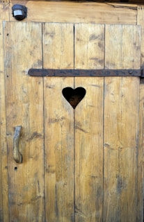 A heart shaped hole in a wooden door