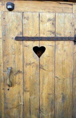A heart shaped hole in a wooden door