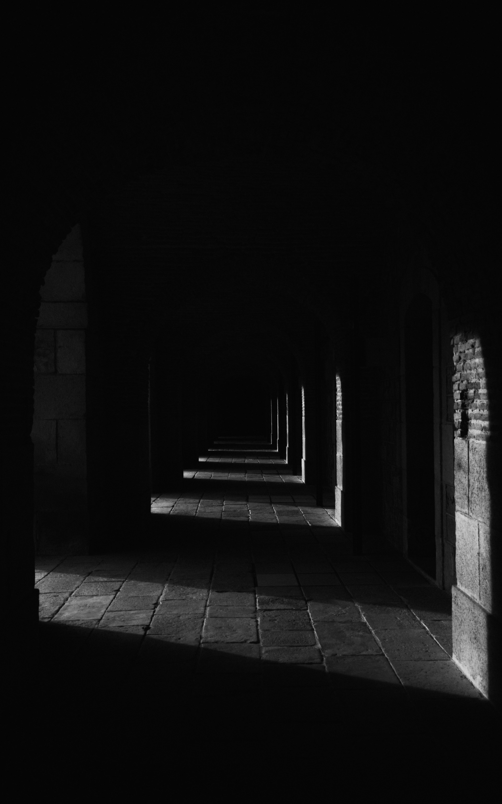 A black and white photo of a long hallway