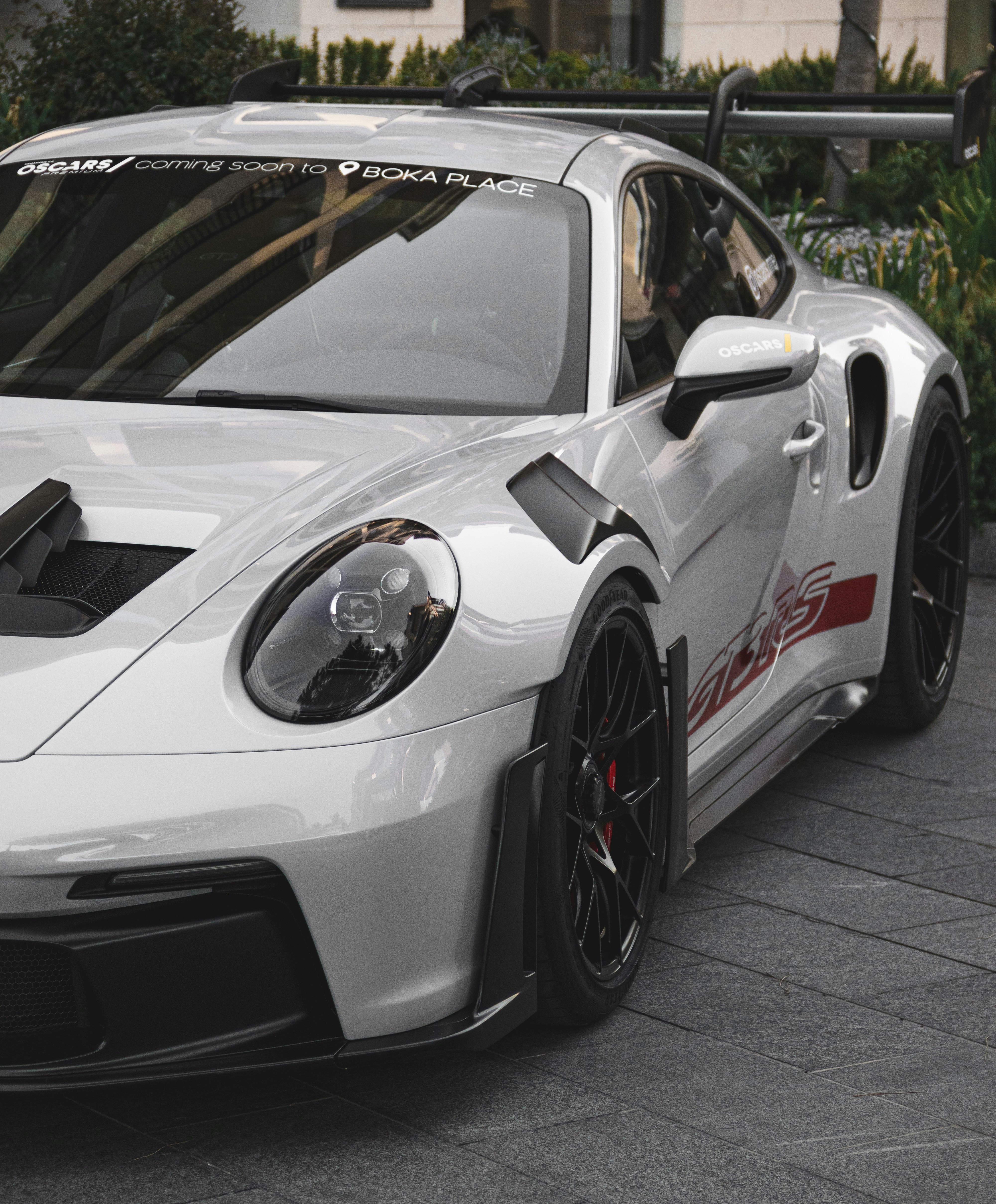 A white sports car parked in front of a building