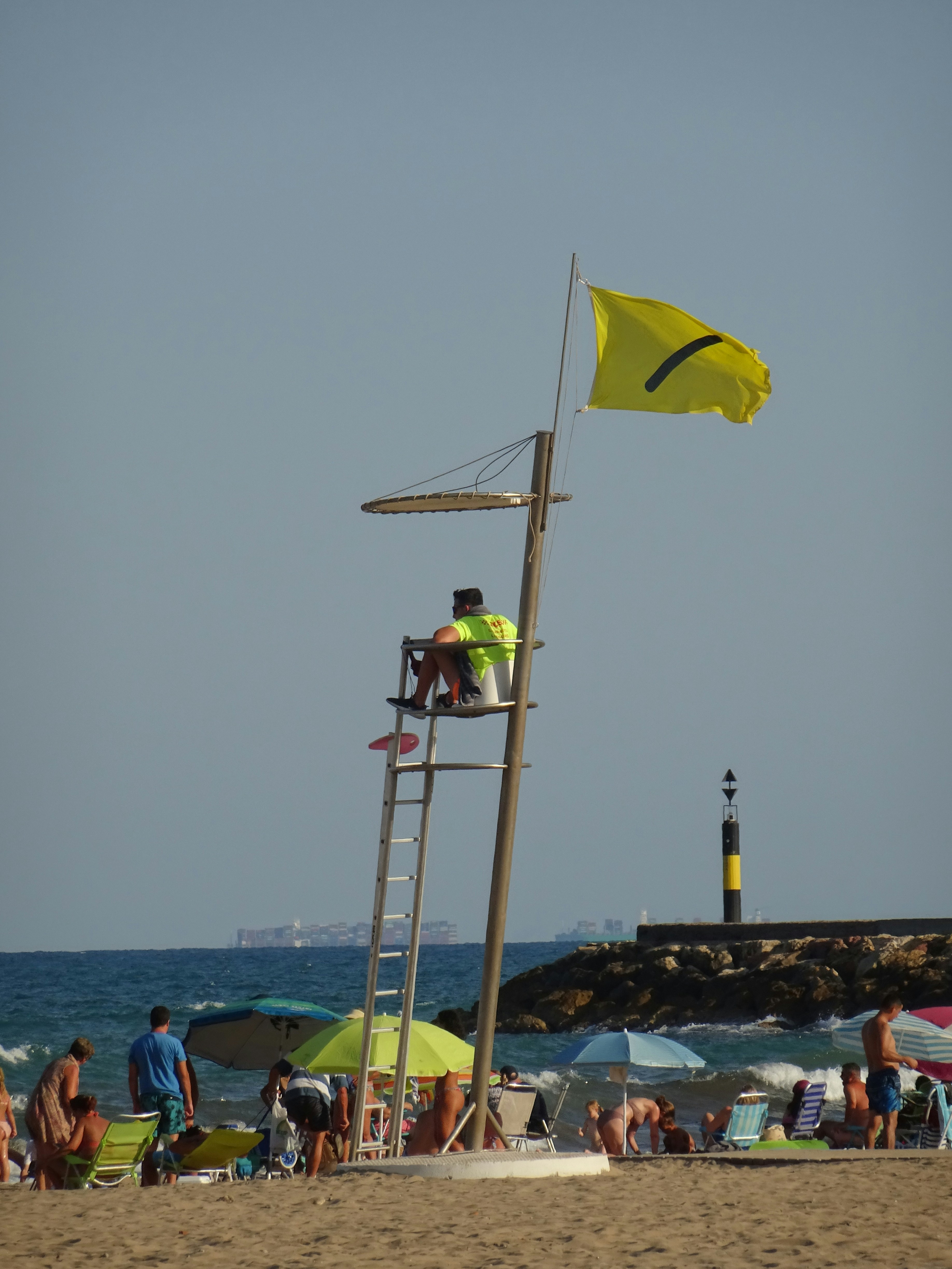 Un socorrista vigilando la playa con bandera amarilla.