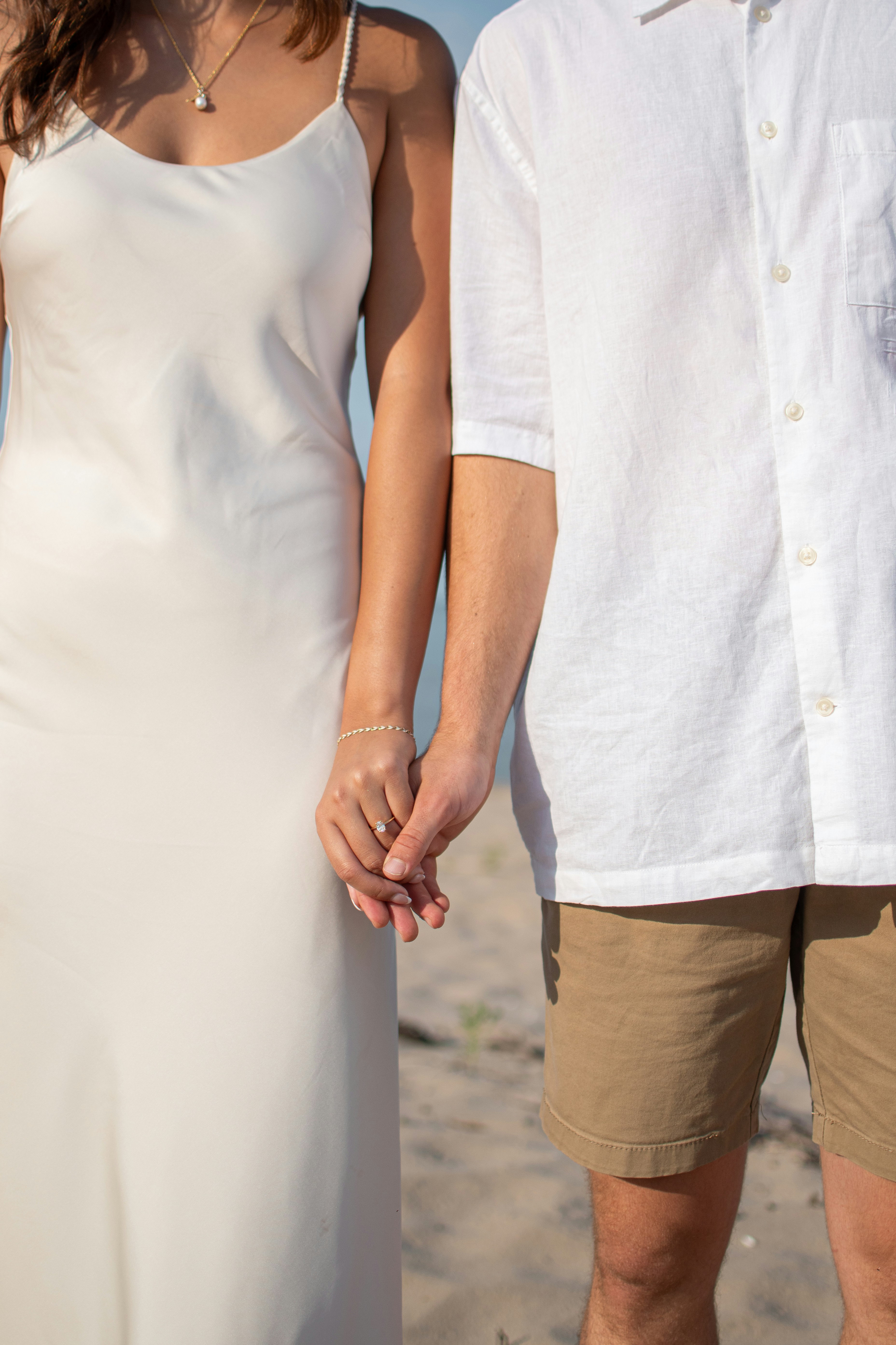 A man and a woman holding hands on a beach