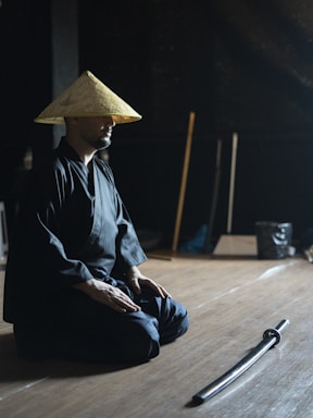 A man sitting on the floor with a hat on his head