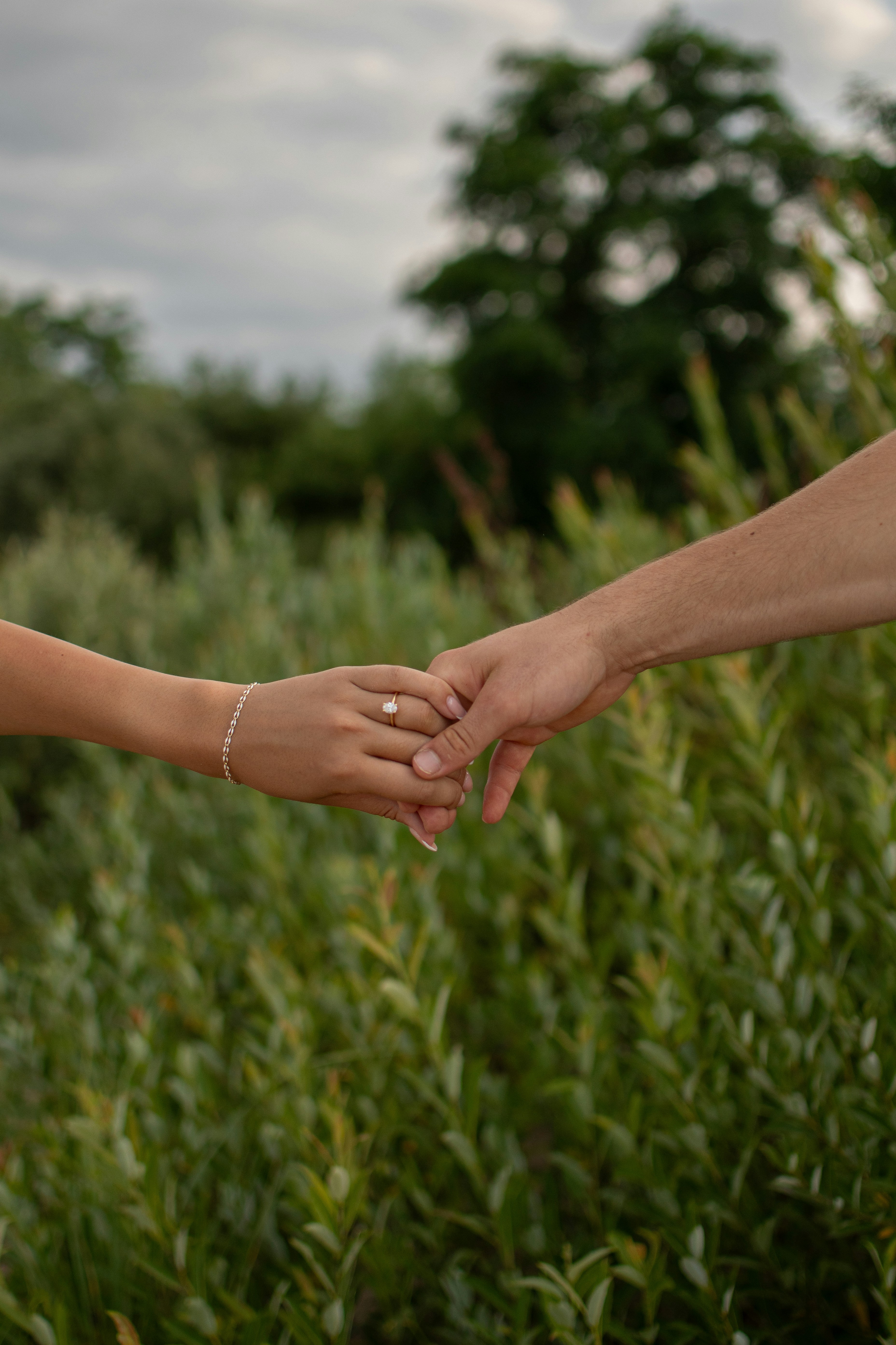 A bride and groom holding hands in a field