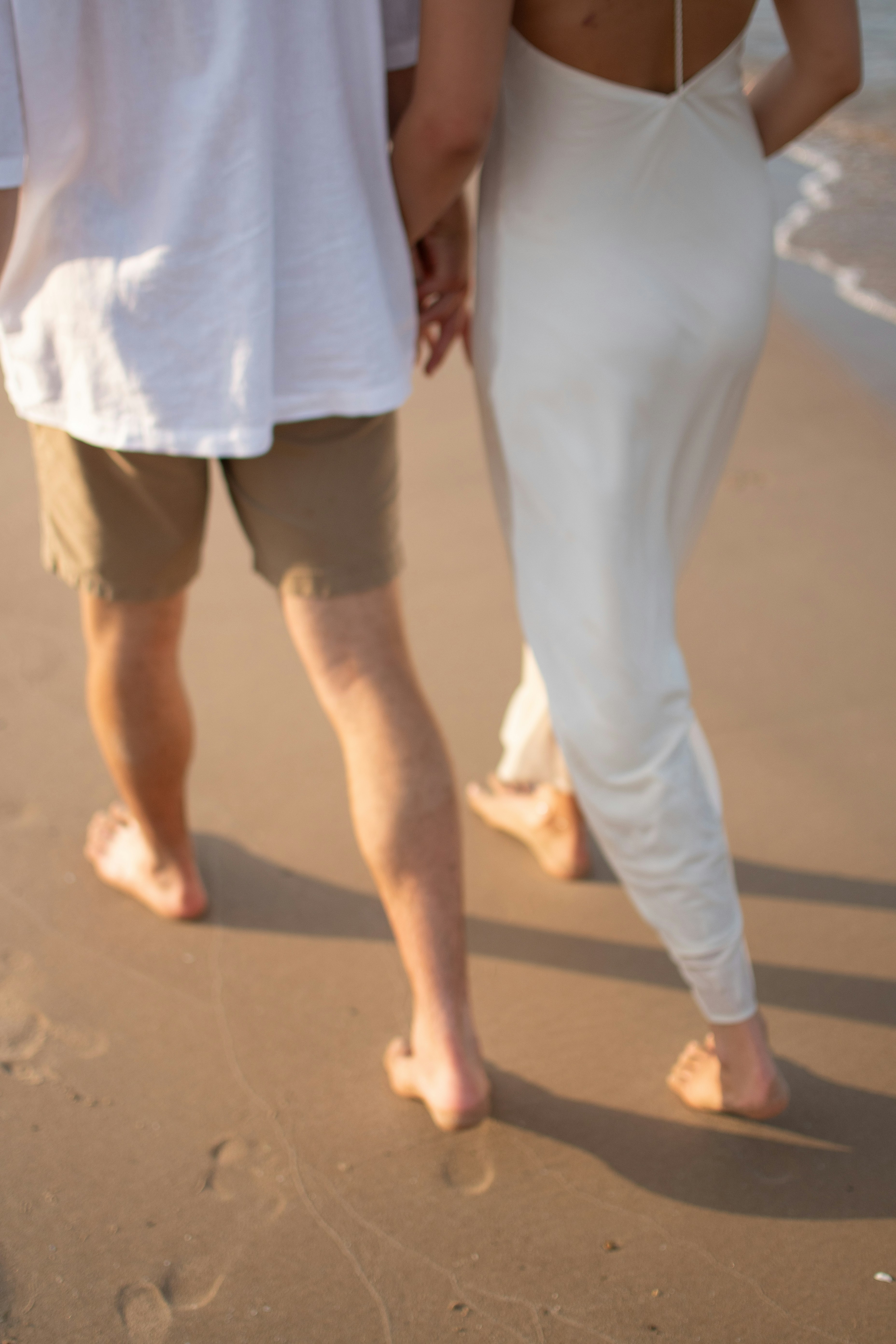 A man and a woman walking on the beach