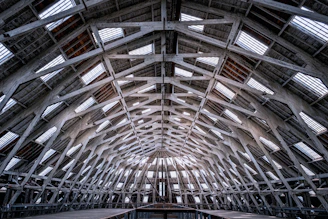 The inside of a building with a roof made of metal beams