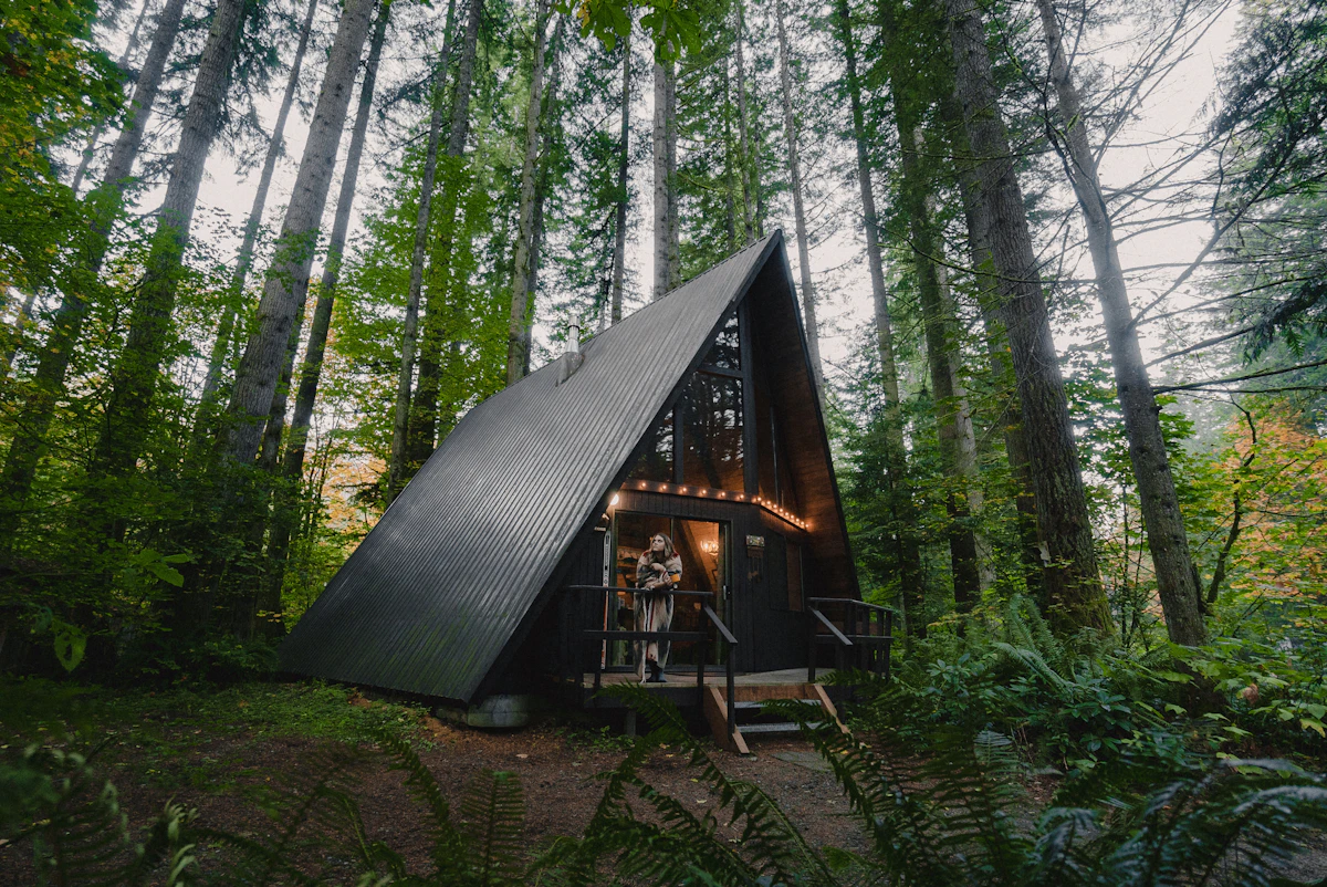 Pequeña cabaña de madera en medio del bosque de montaña