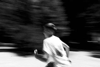 A blurry photo of a boy running in the street