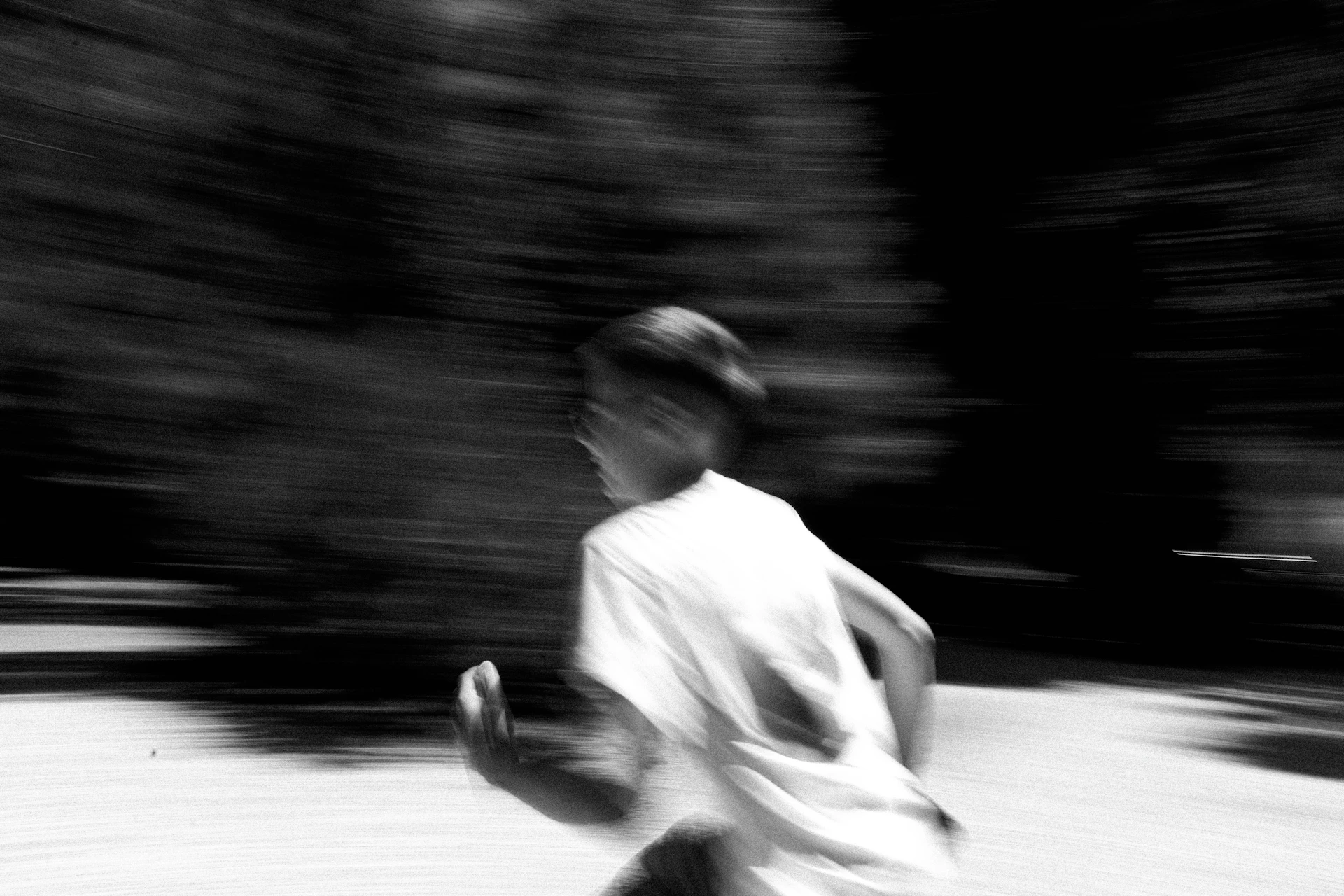 A blurry photo of a boy running in the street