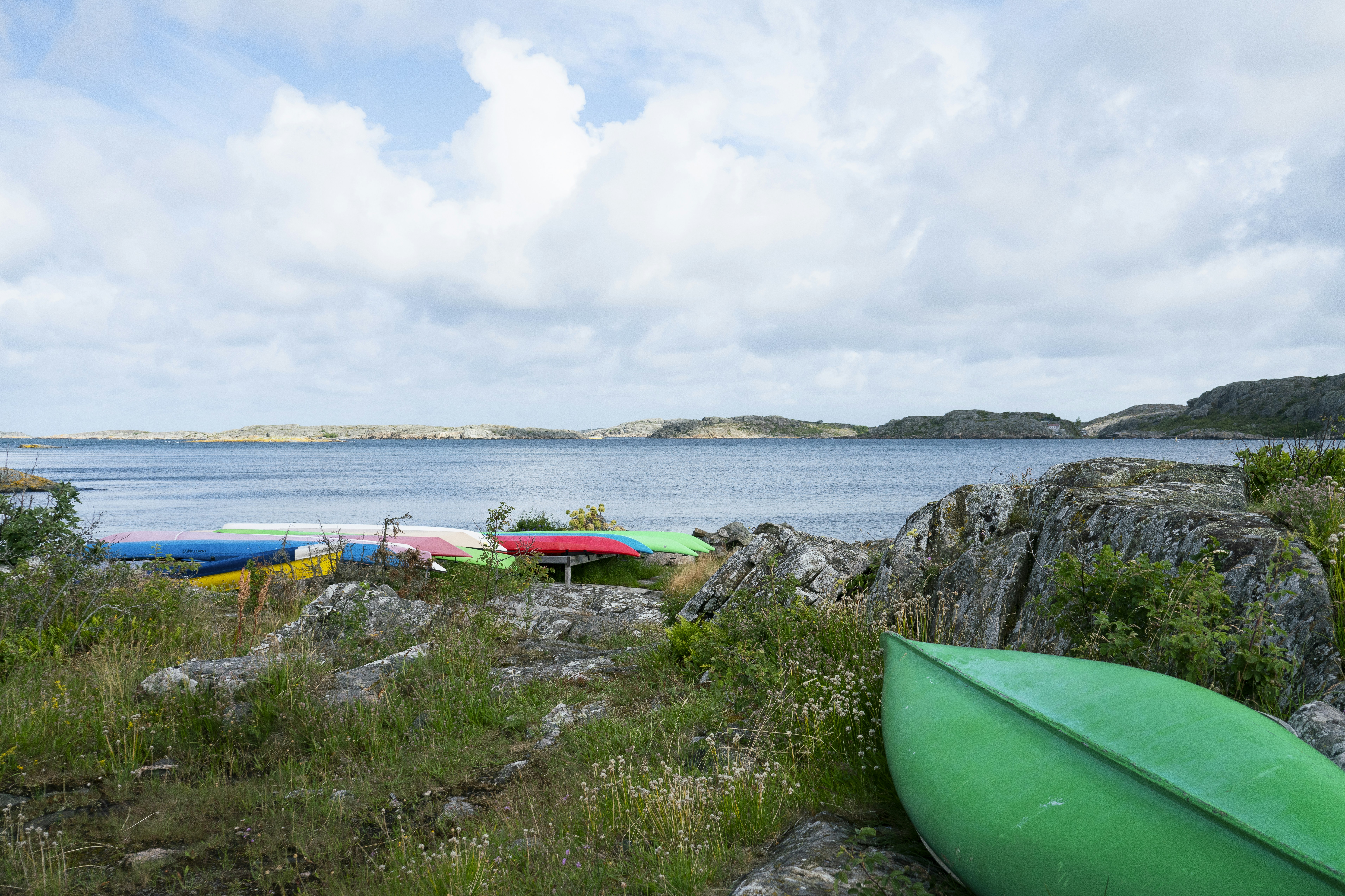 A green surfboard sitting on top of a rocky beach