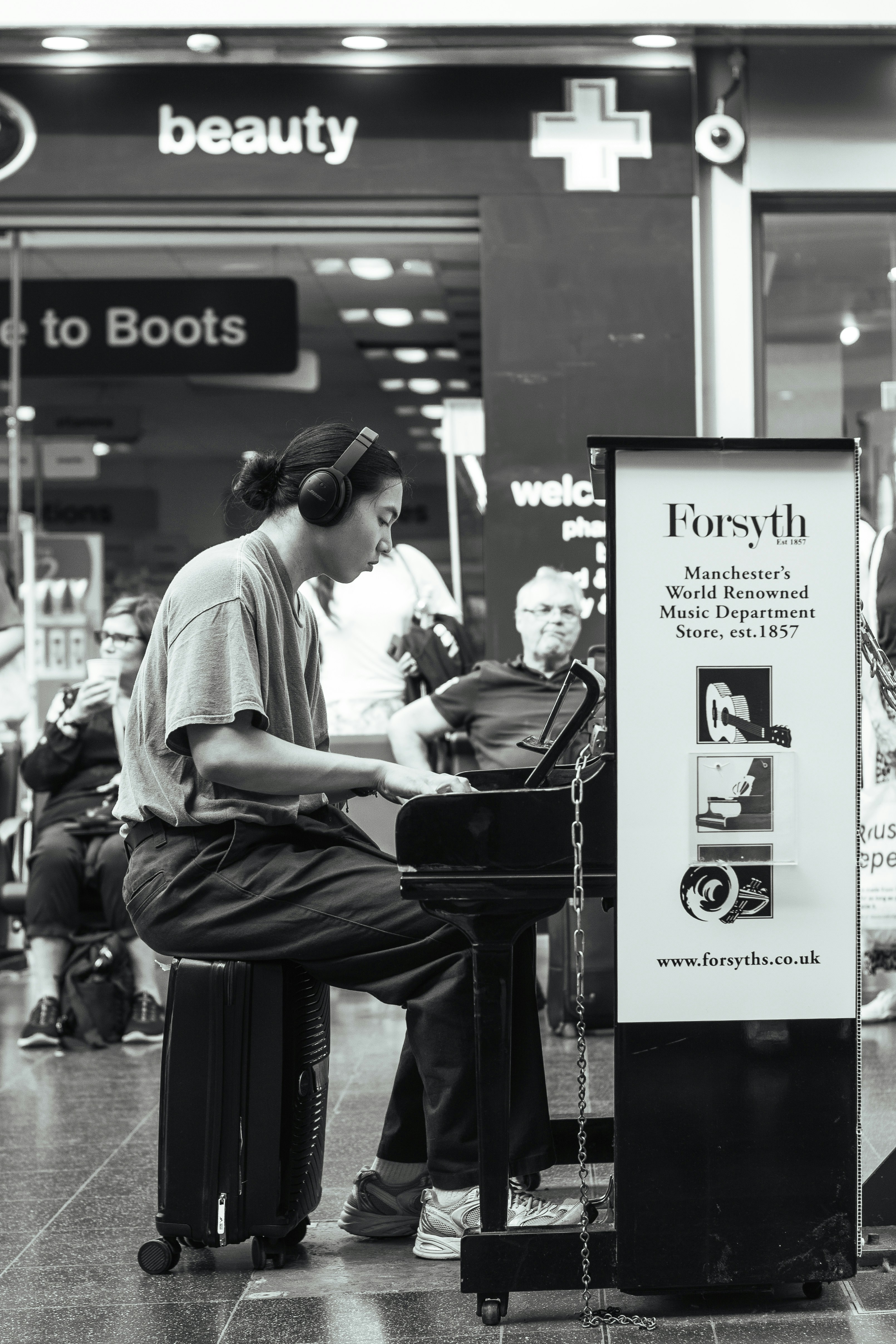 A woman sitting at a piano in front of a store