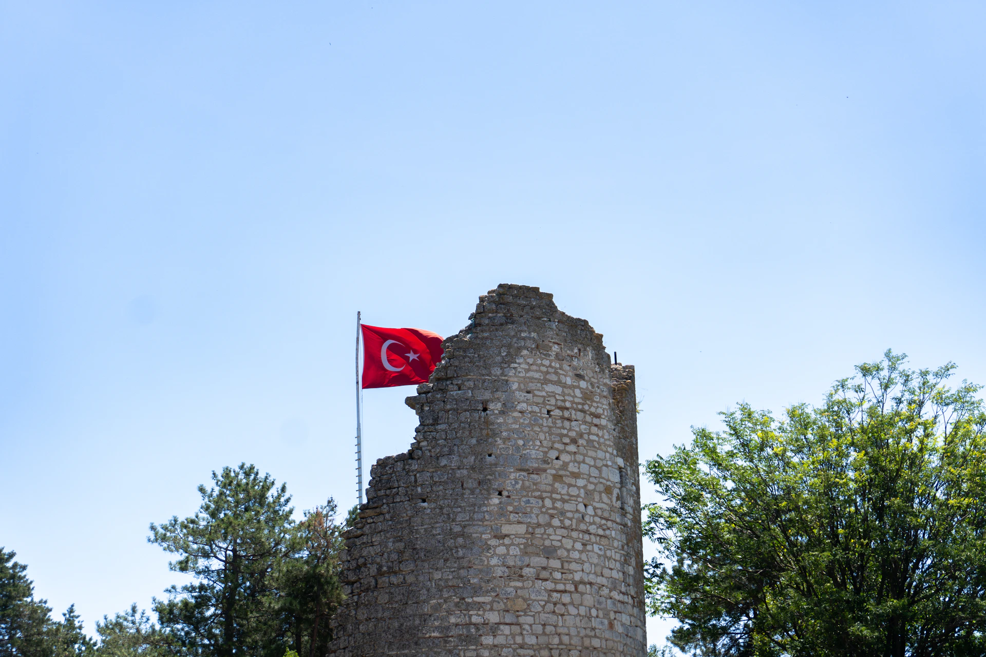 A stone tower with a flag on top of it
