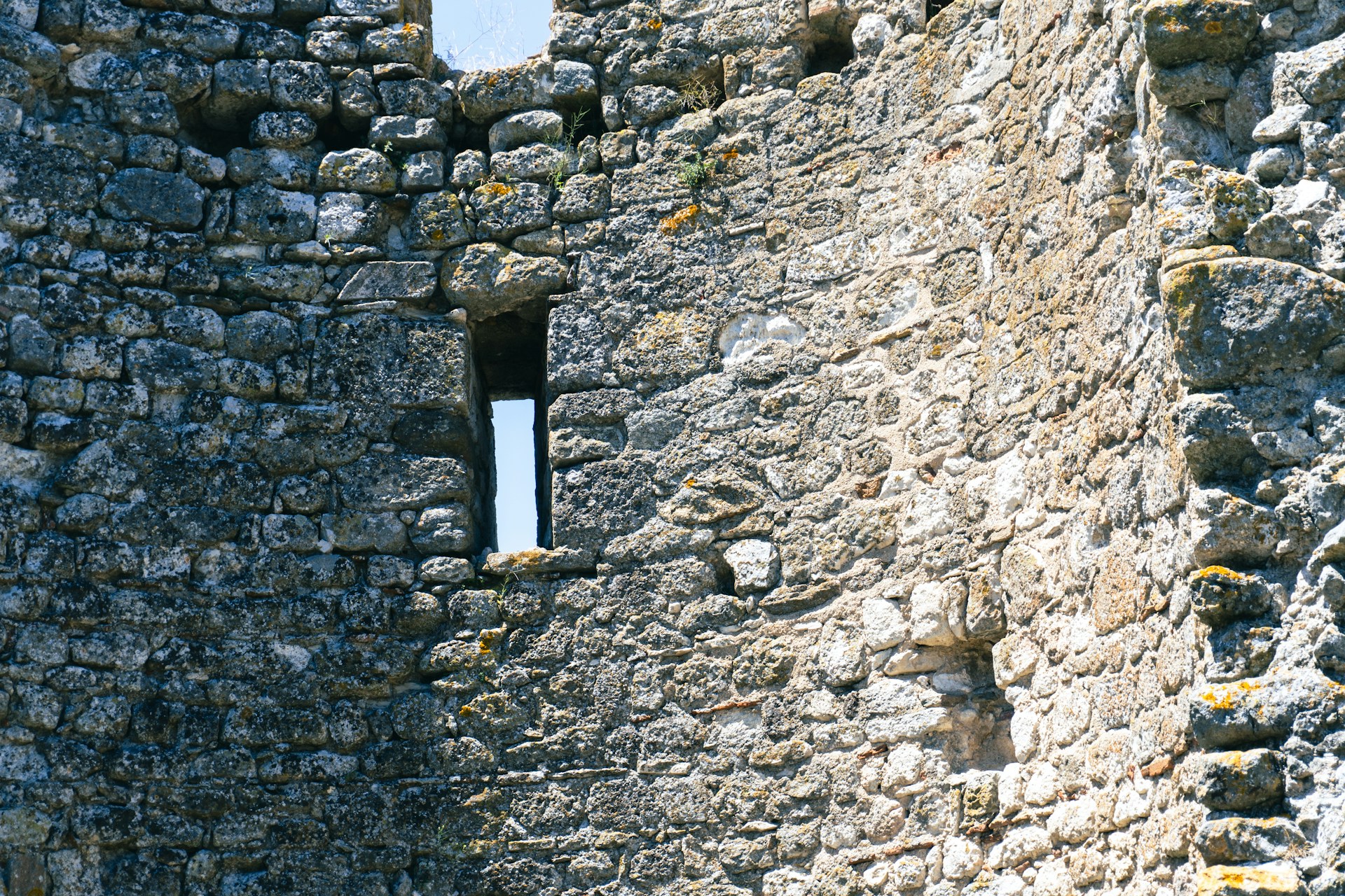 A stone wall with a window in it